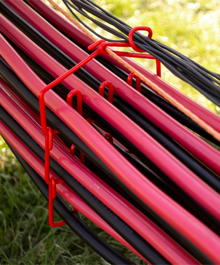Red and black electrical cables organized in a CAB ModulAir® rack system at an outdoor installation site.
